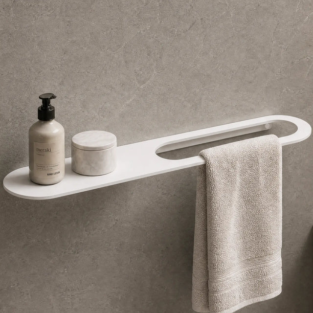 Bathroom setup with a shelf, towel, and toiletries against a gray wall.