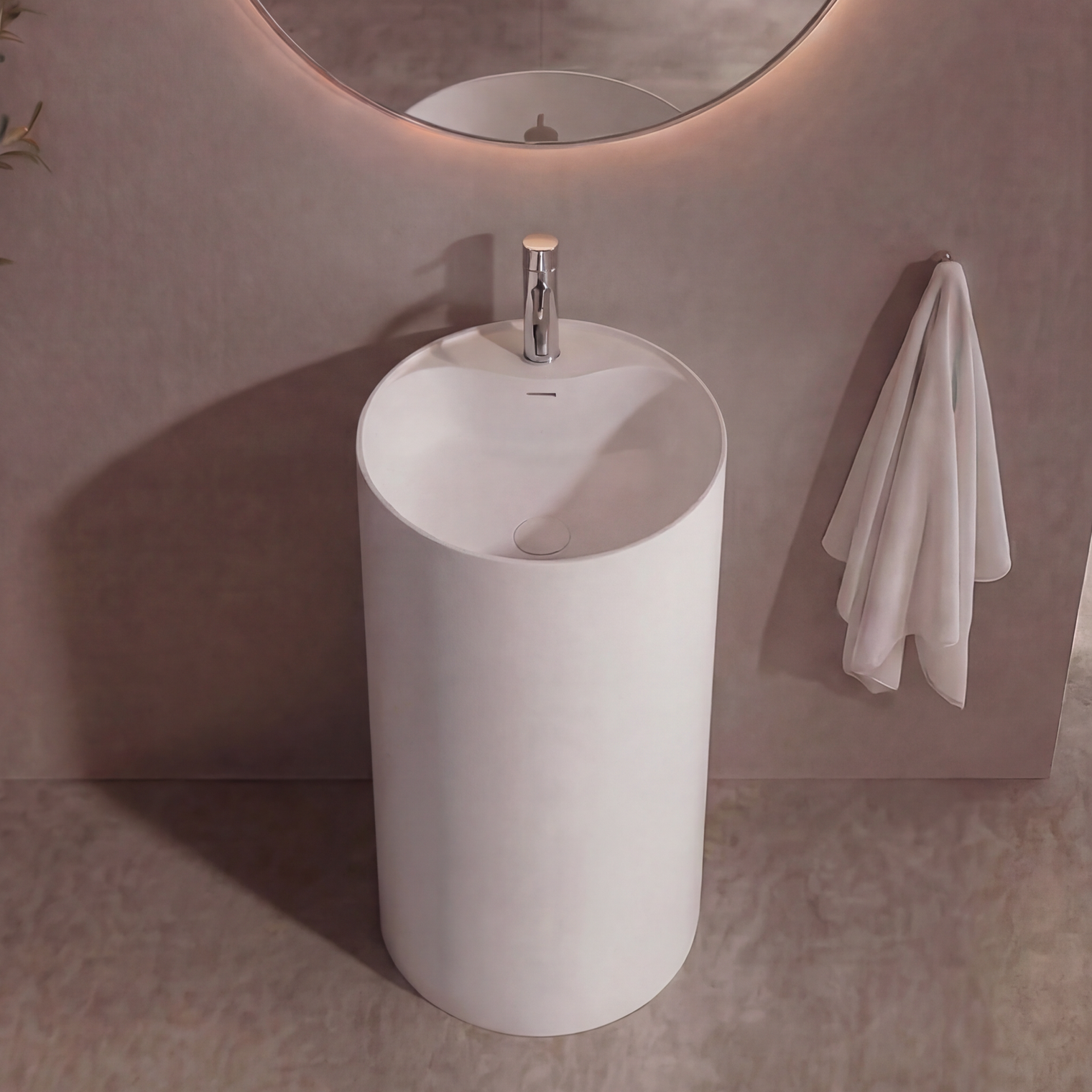 Modern bathroom with a round mirror, white freestanding sink, and decorative plant.