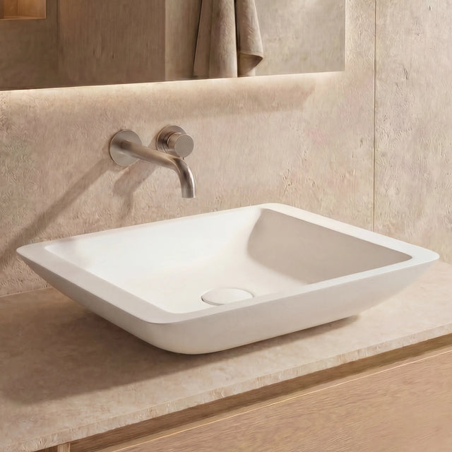 Bathroom vanity with a white sink and wooden cabinet.