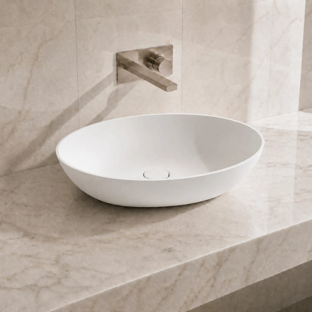 White ceramic sink on a marble countertop with a matching wall-mounted faucet.