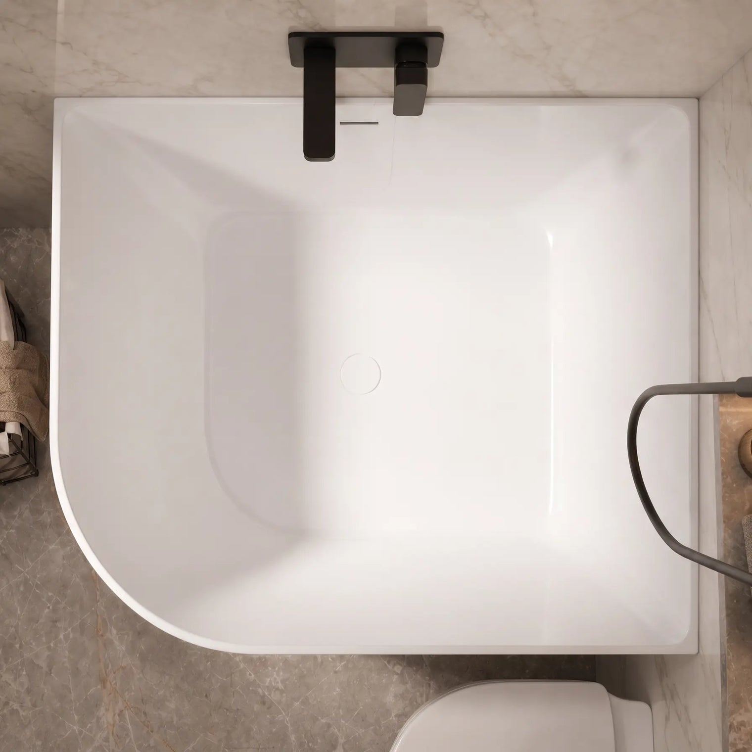A top-down view of a modern freestanding bathtub in a bathroom setting with gray marble tiles, matte black fixtures, and a small basket of towels on the side.