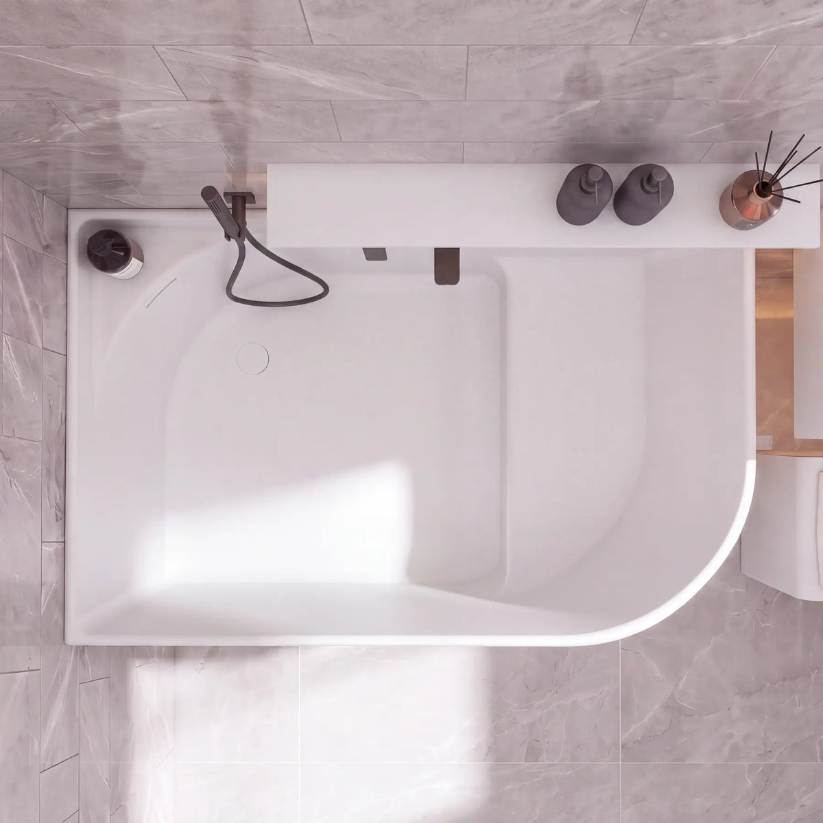 A modern white freestanding bathtub with a matte black handheld shower and faucet, shown from a top-down view in a tiled bathroom with gray stone-look tiles.