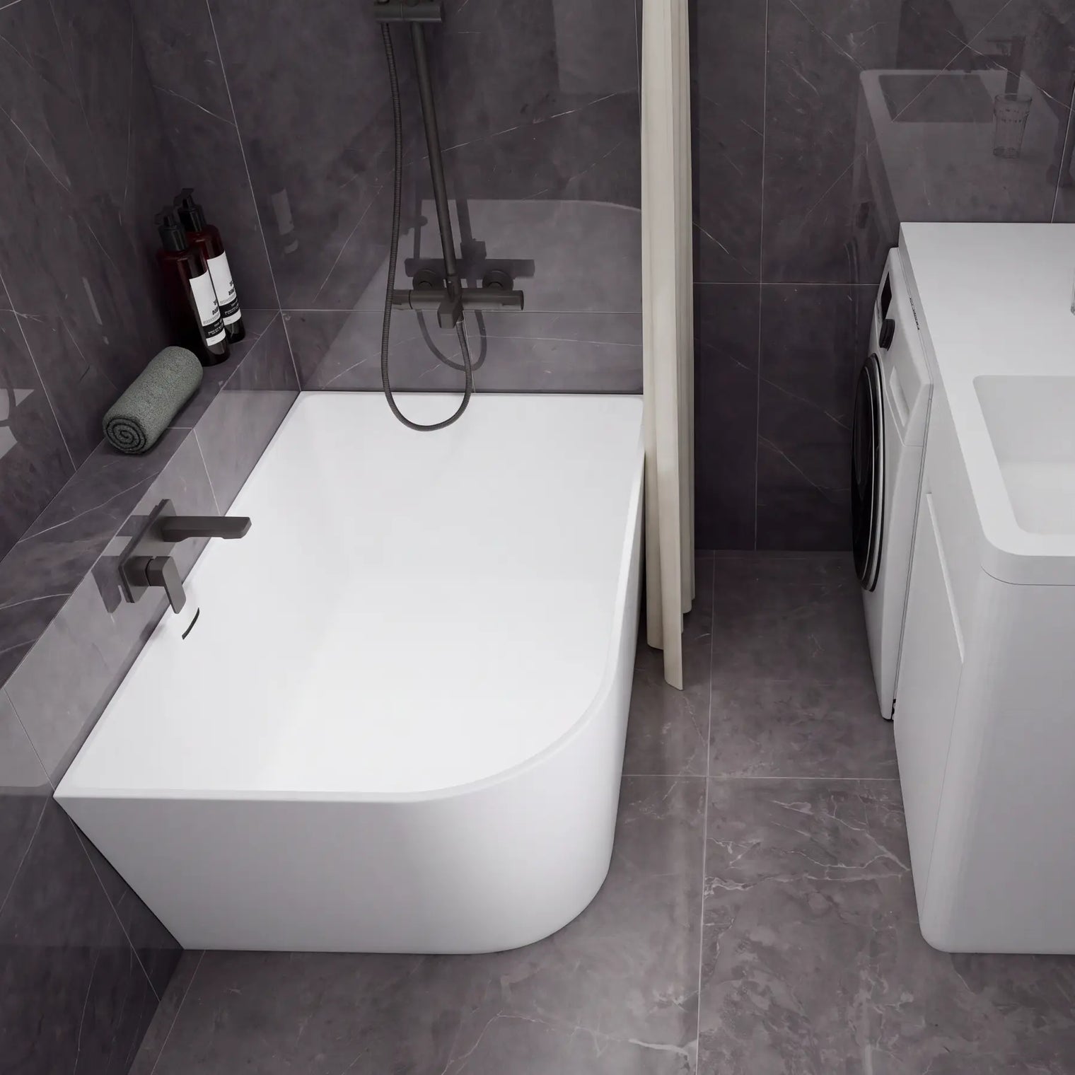 A modern bathroom setup featuring a white freestanding bathtub with a dark wall-mounted faucet and shower system, alongside a white sink vanity with a matching dark faucet and a small washing machine, all set against dark gray tiled walls and floor.