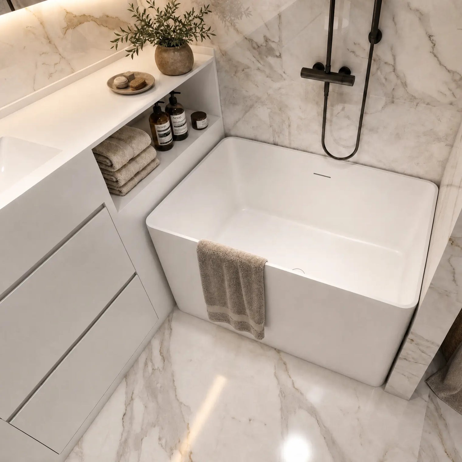A modern freestanding white bathtub installed in a marble bathroom, with a black wall-mounted shower fixture, beige towels, a vanity shelf with toiletries, and a woven basket on the floor.