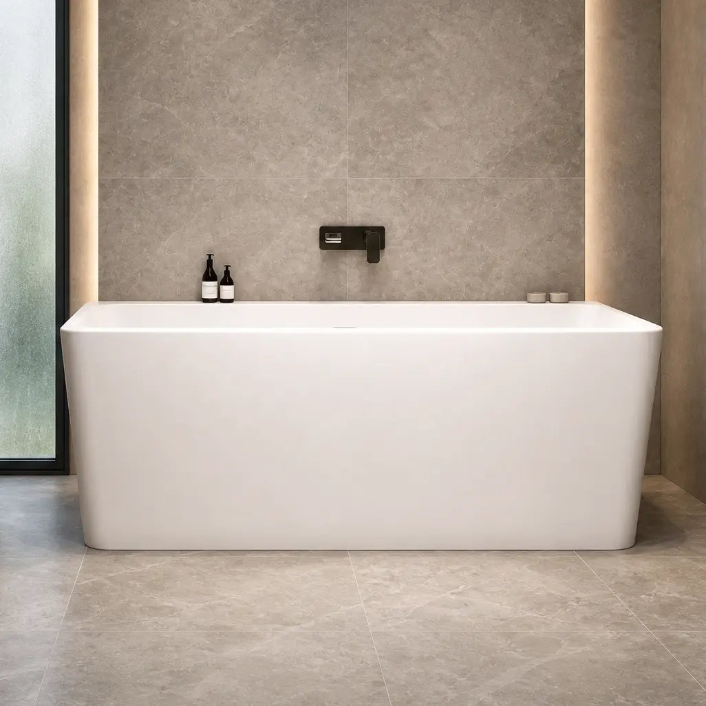 A modern bathroom interior featuring a freestanding white bathtub centered against a textured gray stone wall with warm LED lighting, alongside a floating white sink, mirror, toilet, and open shelving.