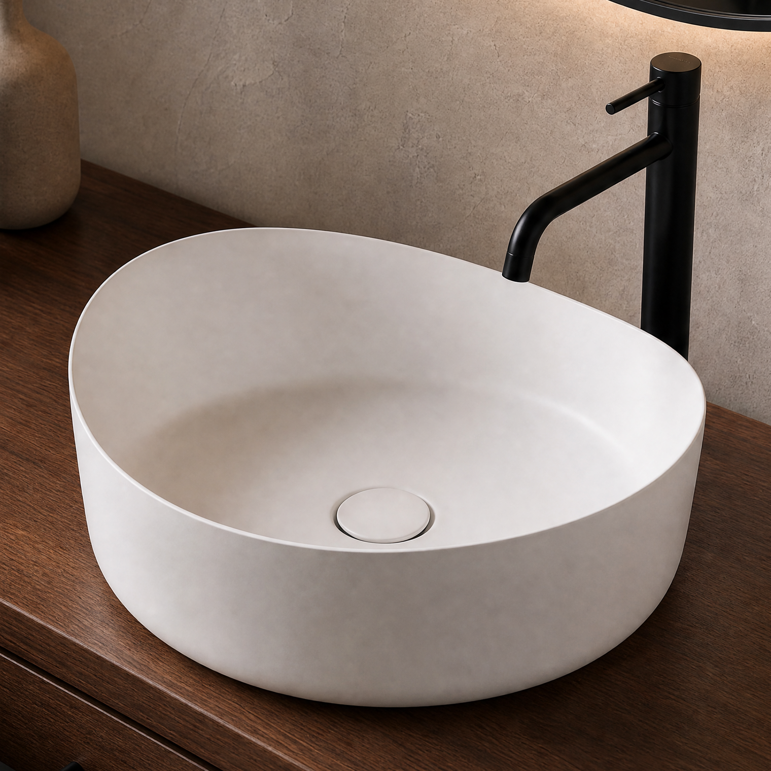 White solid surfaces sink on a wooden vanity with a black faucet and decorative items.