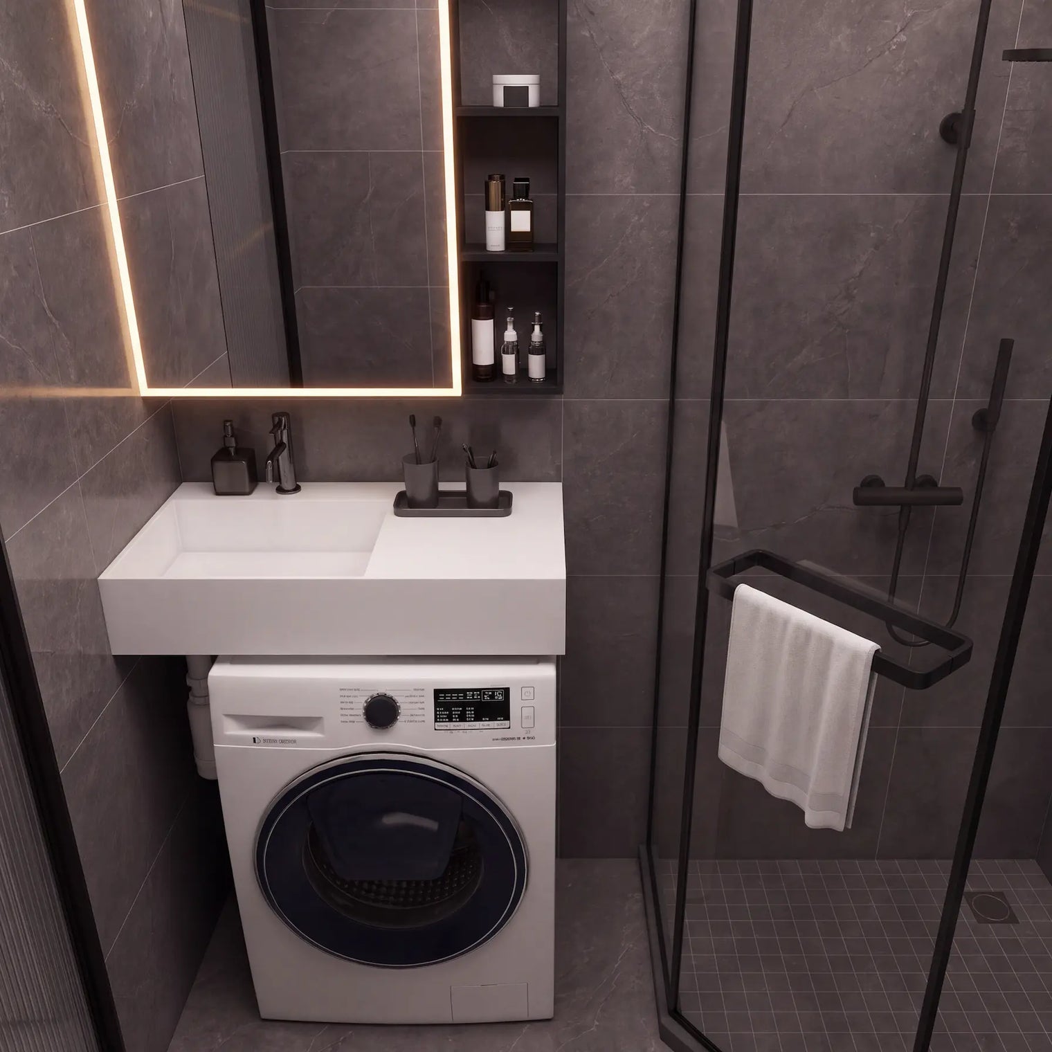 A modern bathroom scene featuring a white wall-mounted sink and washing machine combo, a black-framed glass shower enclosure, dark gray stone-look tiles, and a lit mirror.