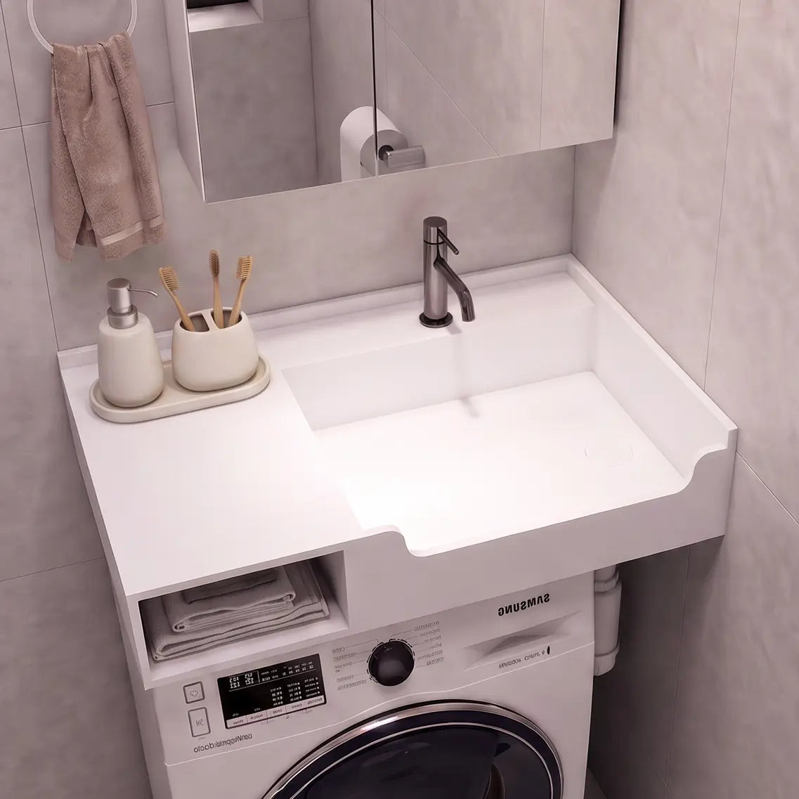 A compact bathroom vanity setup with a white sink and countertop, integrated washing machine underneath, shown in a tiled bathroom. A mirror, faucet, soap dispenser, and toilet paper holder are visible.