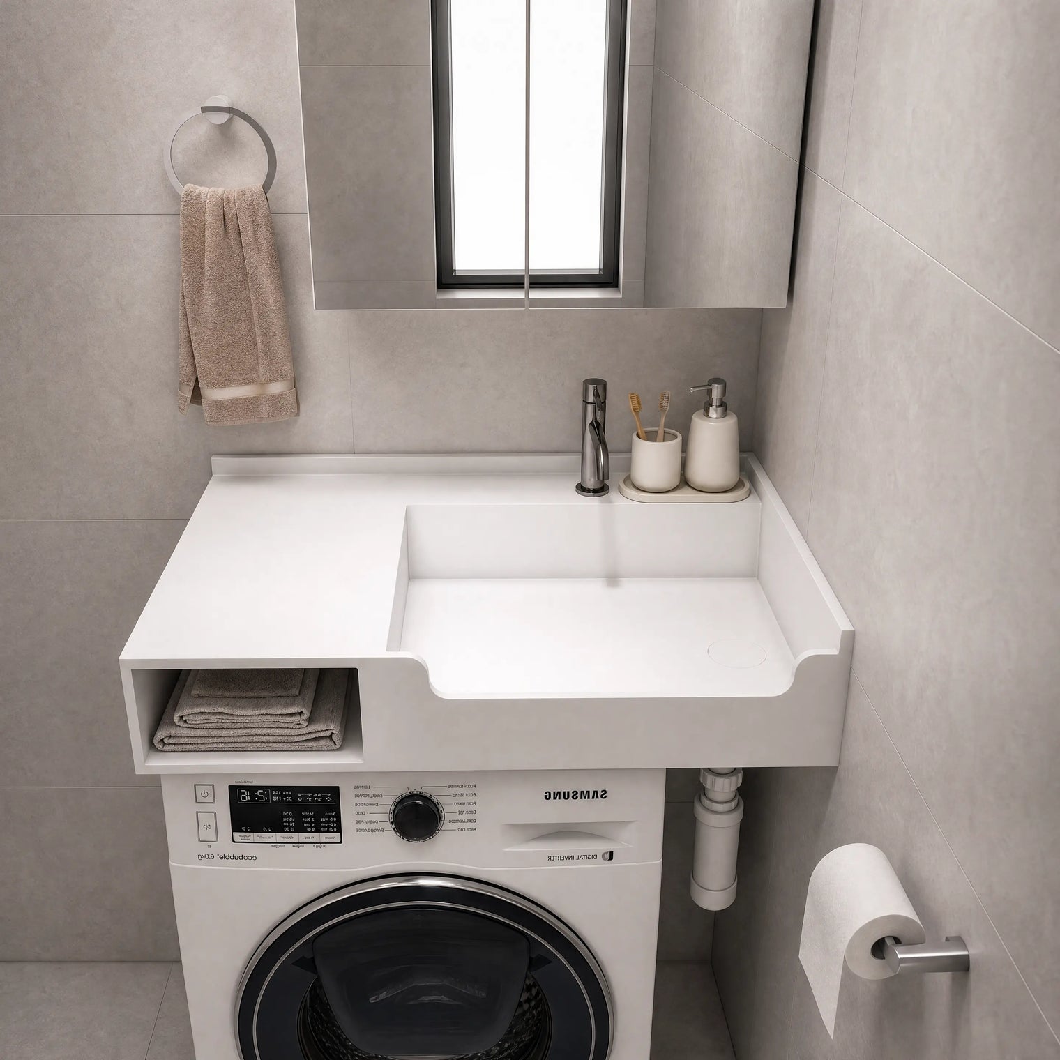 A white wall-mounted laundry sink and washer combo unit in a modern gray tiled bathroom. The white countertop features a rectangular sink basin, a side storage shelf with folded towels, a chrome faucet, and a built-in Samsung washing machine underneath.