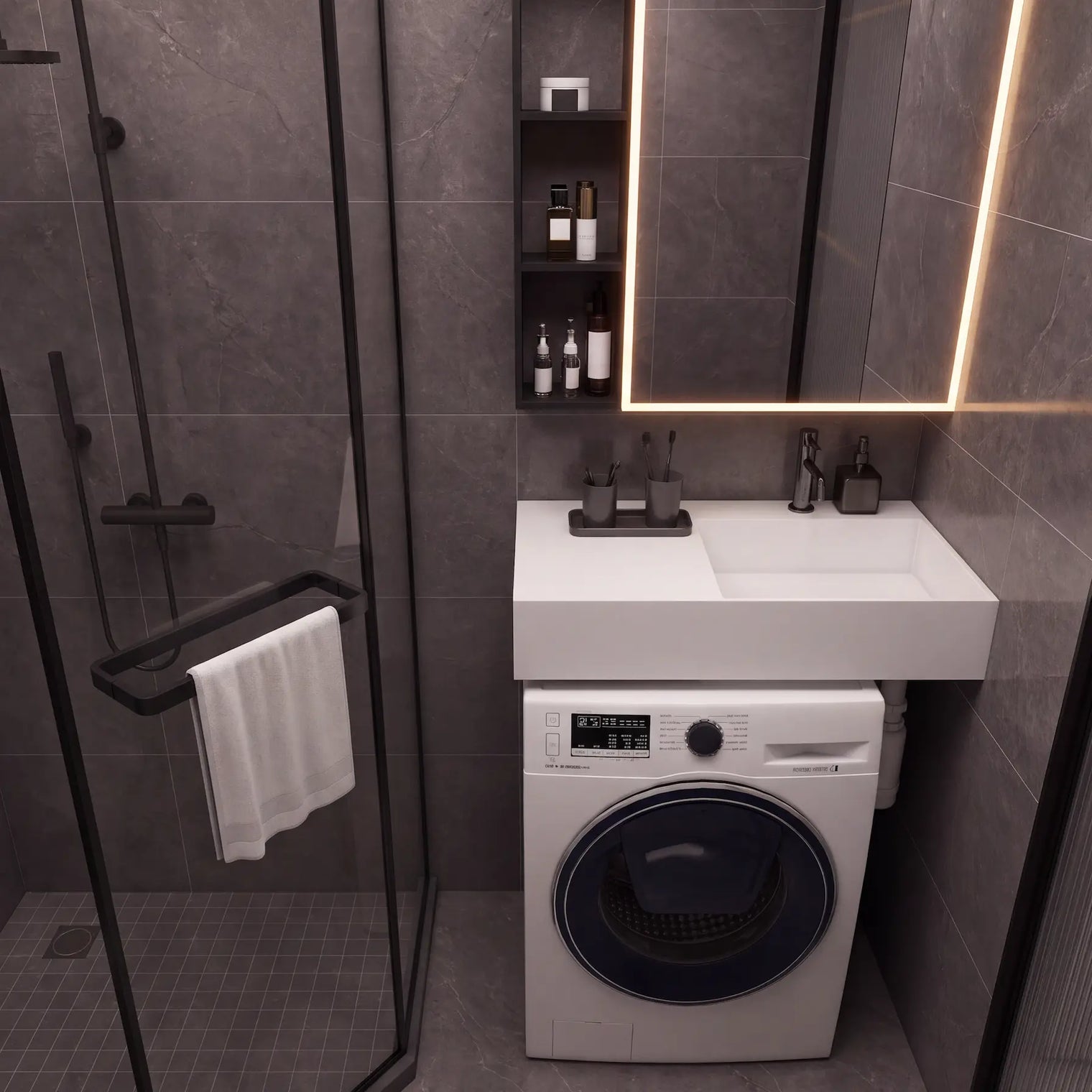 A modern bathroom scene featuring a white wall-mounted sink and washing machine combo, a black-framed glass shower enclosure, dark gray stone-look tiles, and a lit mirror.