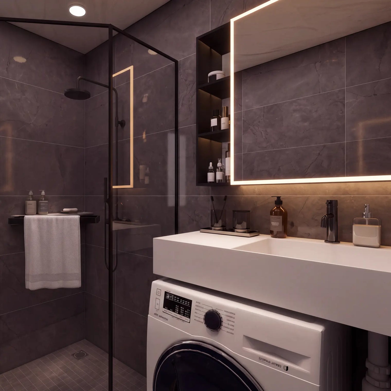 A modern bathroom interior with dark gray tiled walls, a white countertop and sink, a glass shower enclosure, a white washing machine, and part of a white toilet visible.