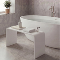 Modern bathroom with a freestanding bathtub, white bench, and decorative items.