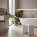 Modern bathroom with a freestanding bathtub, sink, and decorative elements.