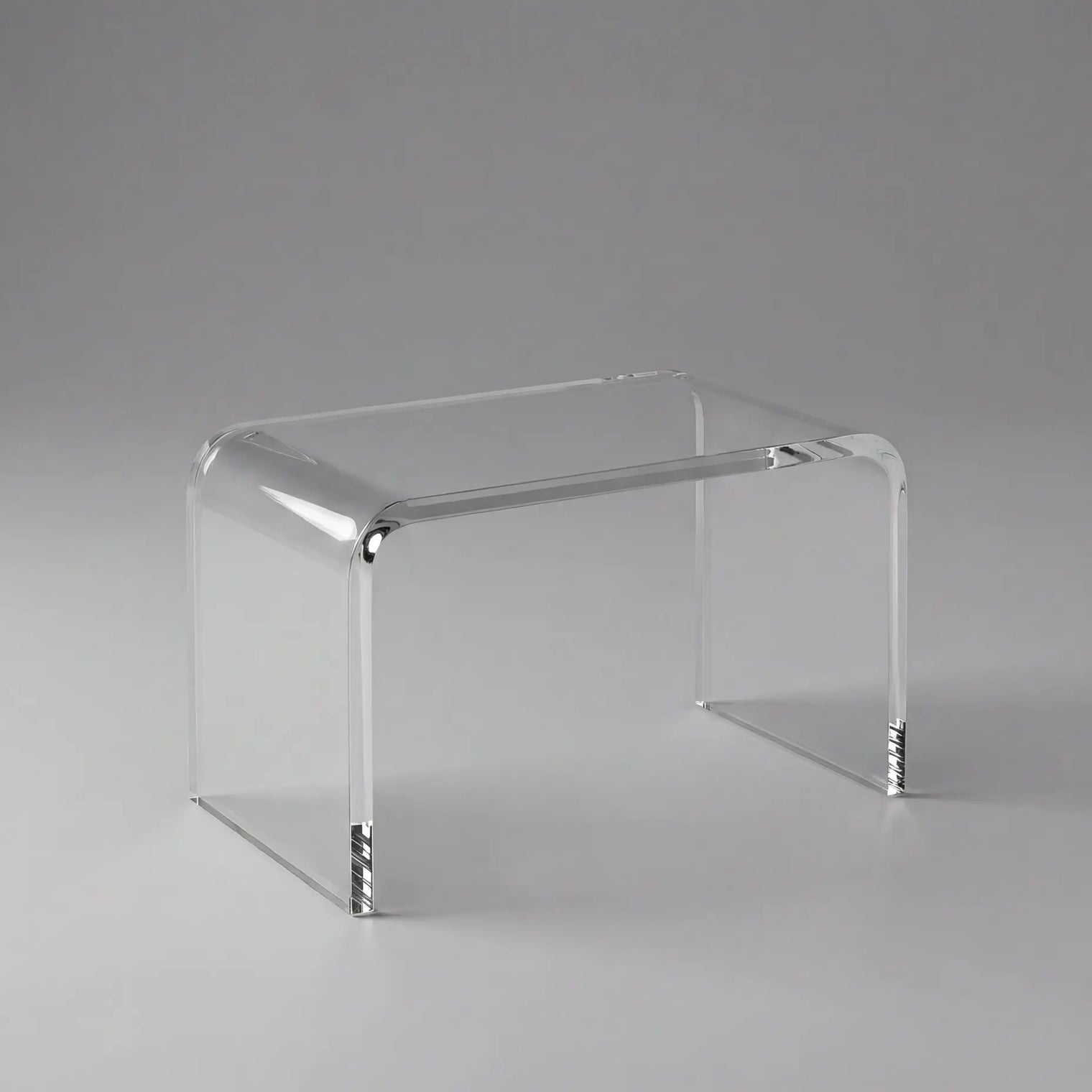 Clear acrylic side table on a gray background