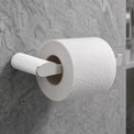 Roll of toilet paper on a holder against a tiled bathroom wall.