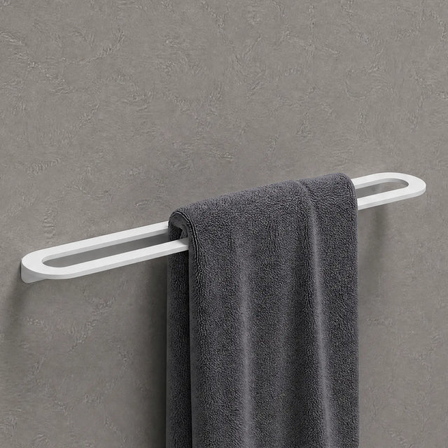 Gray towel hanging on a white towel rack against a gray wall.
