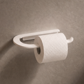 Wall-mounted toilet paper holder with a roll of toilet paper on a bathroom wall.