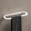 Towel rack with a black towel on a gray wall in a bathroom setting.