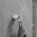 Gray towel hanging on a wall hook in a modern bathroom.