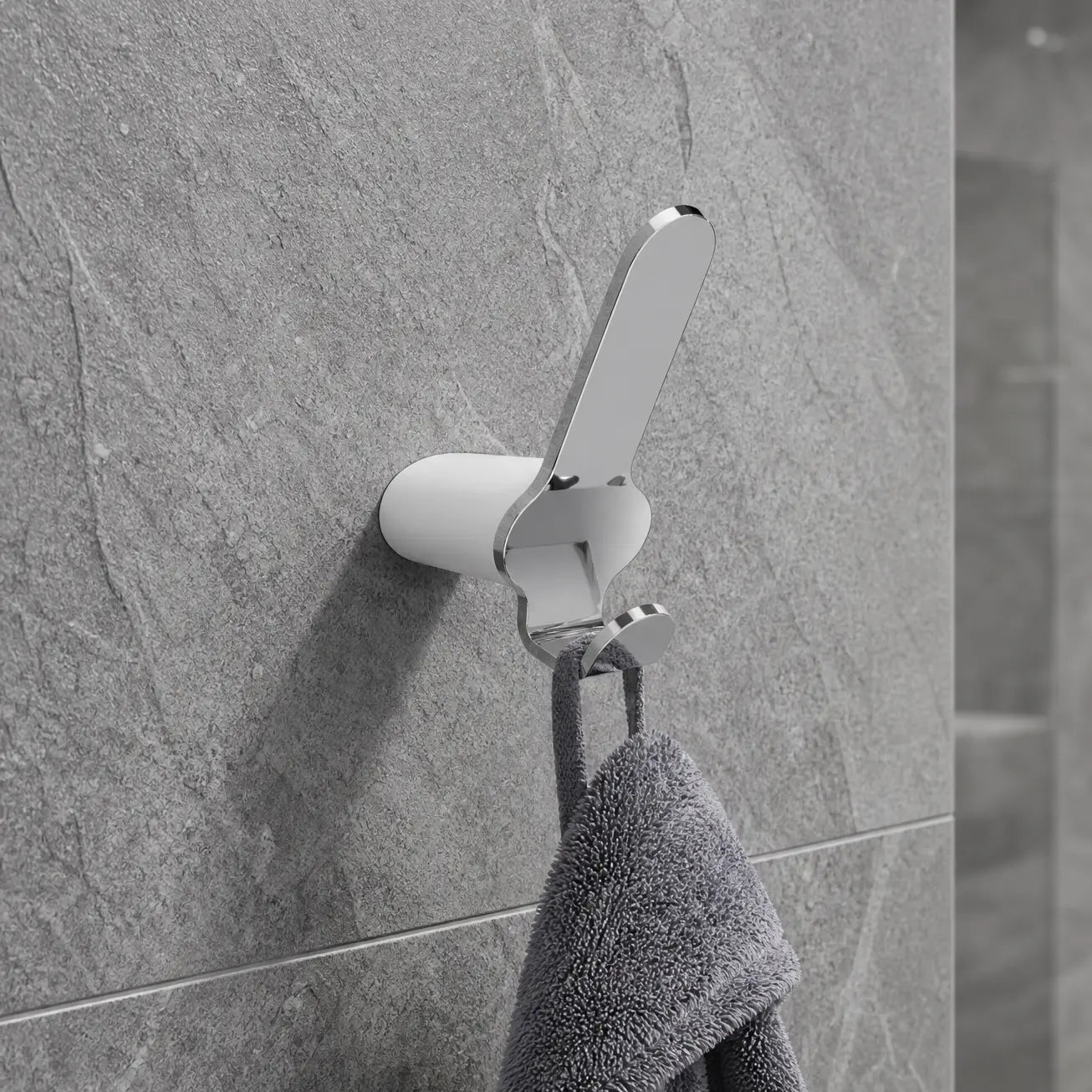 Gray towel hanging on a wall hook in a modern bathroom.