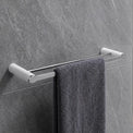 Gray towel hanging on a towel rack in a modern bathroom with gray tiles.