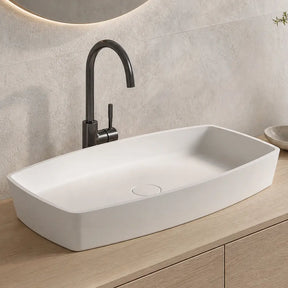 Bathroom vanity with white sink, black faucet, and wooden cabinet.