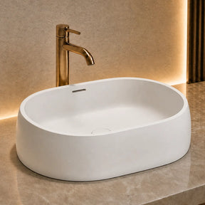 Modern bathroom solid surfaces sink with gold faucet on a marble countertop