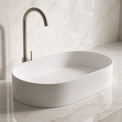 White Solid Surfaces oval sink on a marble countertop with a matching wall.