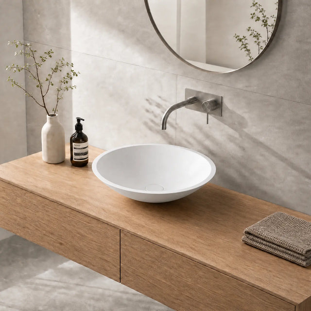 Bathroom vanity with wooden countertop, white sink, and decorative items.