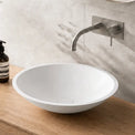 Bathroom vanity with wooden countertop, white sink, and decorative items.