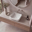 Bathroom vanity with a square sink, faucet, and decorative items.