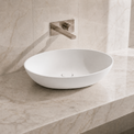 White ceramic sink on a marble countertop with a matching wall-mounted faucet.