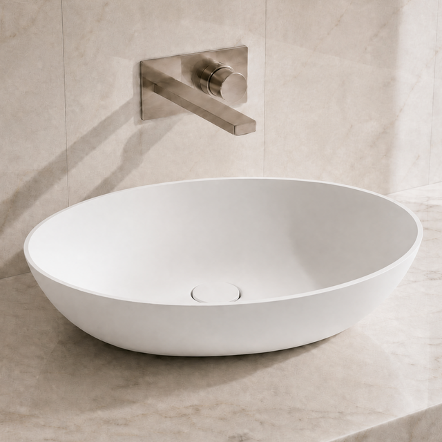 White ceramic sink on a marble countertop with a matching wall-mounted faucet.
