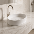 White Solid Surfaces oval sink on a marble countertop with a silver faucet.