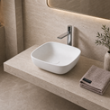 Bathroom vanity with white solid surfaces sink, faucet, and decorative elements.