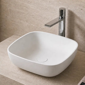 Bathroom vanity with white solid surfaces sink, faucet, and decorative elements.