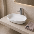 Bathroom Solid Surfaces sink with faucet and towel on a beige countertop