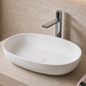 Bathroom Solid Surfaces sink with faucet and towel on a beige countertop