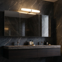 Bathroom vanity with a large mirror in a dark marble setting