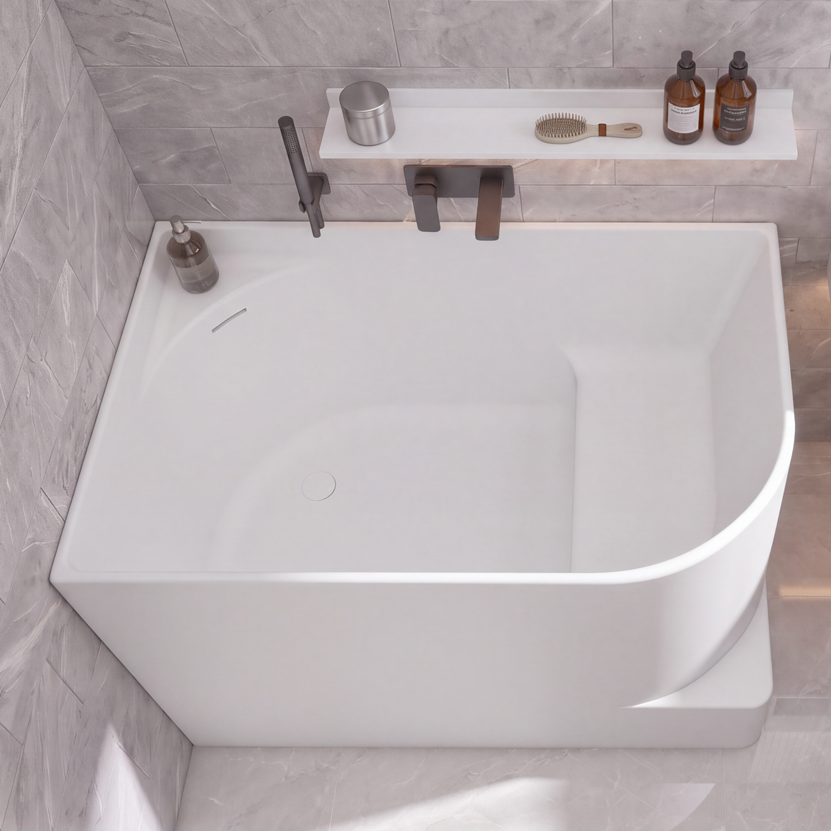 A modern bathroom scene with a large white freestanding bathtub, a white wall-mounted sink, gray stone tile walls and floor, and a few small bathroom accessories and towels.