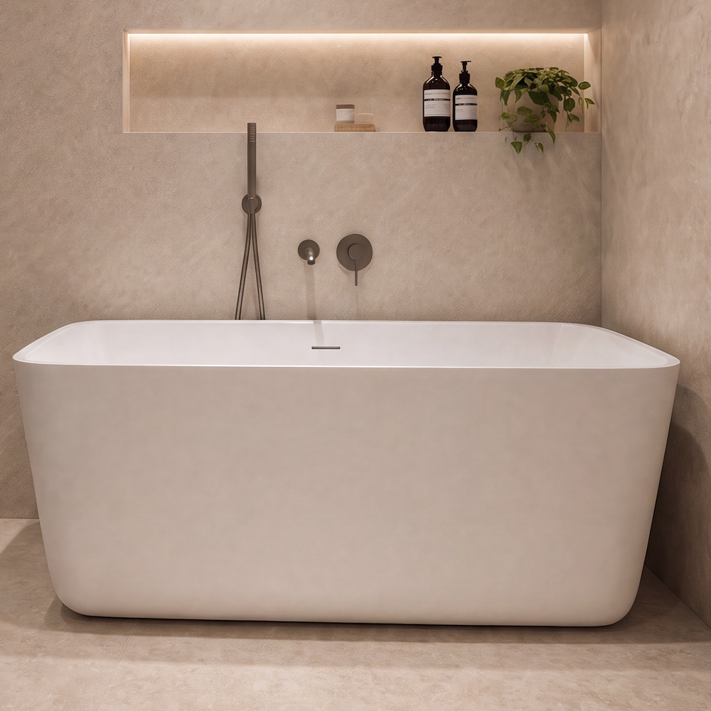 A modern freestanding bathtub in a minimalist beige-toned bathroom with a glass shower enclosure, built-in shelving, and warm ambient lighting.