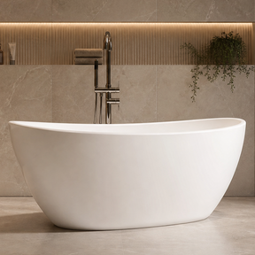 A modern freestanding oval bathtub in white, set in a luxurious bathroom with beige stone walls and floor, featuring a chrome faucet and built-in wood shelving.