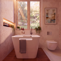 A modern freestanding bathtub in a warm-toned bathroom with wood flooring, textured walls, a window looking out to greenery, a wall-mounted toilet, and framed wall art.
