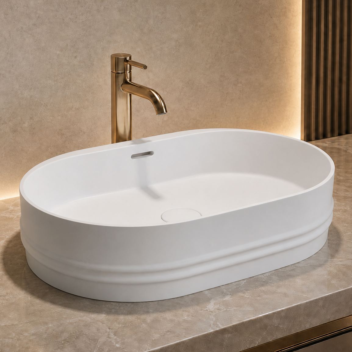 White oval Solid Surfaces sink on a gray countertop with a gold faucet in a modern bathroom setting.