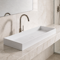 Modern bathroom with a white sink on a marble countertop, large mirror, and shower area.