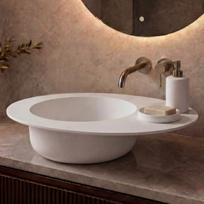 Modern bathroom vanity with a white sink, illuminated mirror, and decorative elements.