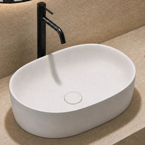 Bathroom sink with black faucet, towel, and plant on beige countertop