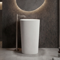 White freestanding sink in a modern bathroom setting with a circular mirror and neutral color palette.