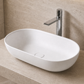 Modern bathroom with a white solid surfaces sink on a beige countertop