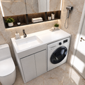 A modern bathroom vanity unit with an integrated white sink and a front-loading washing machine, set against beige marble-look tiled walls. A white toilet is visible on the left, and a white door is on the right.